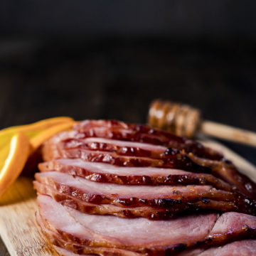 sliced ham n a platter with orange slices