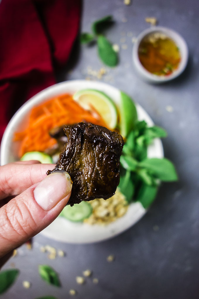 a piece of seared beef being held by fingers