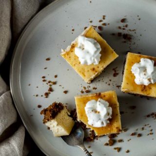 3 eggnog cheesecake bars on a plate with a fork