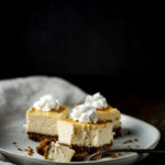 cheesecake bars on a plate with a bite taken out and a fork