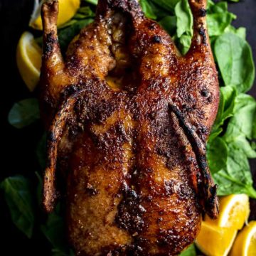 whole roasted duck on a platter