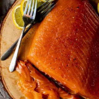 sliced cured salmon on a platter with lemon slices