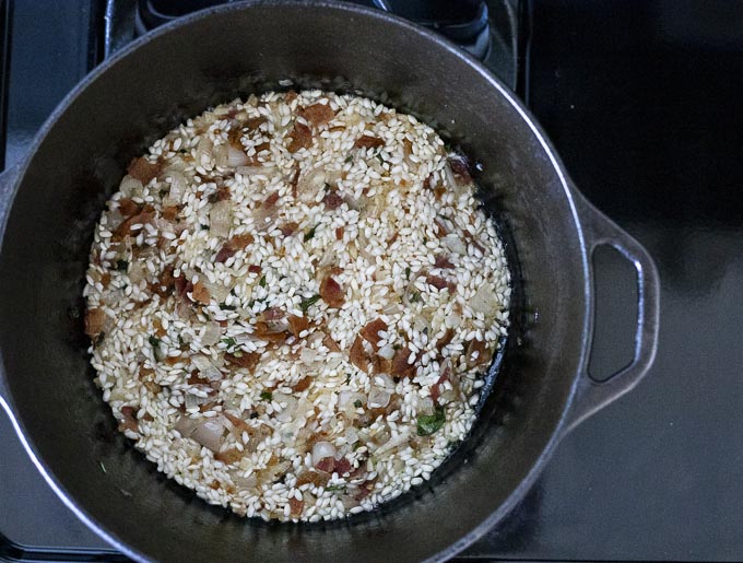 rice and bacon with liquid in a pot
