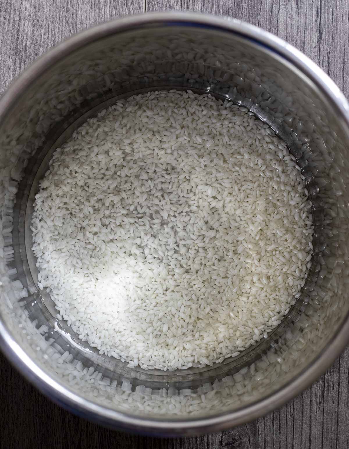 uncooked white rice and water in a pot.