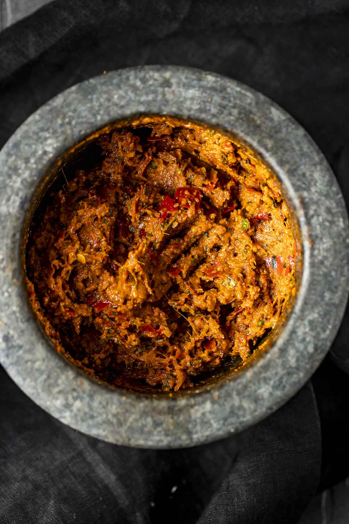 an orange paste in a granite mortar