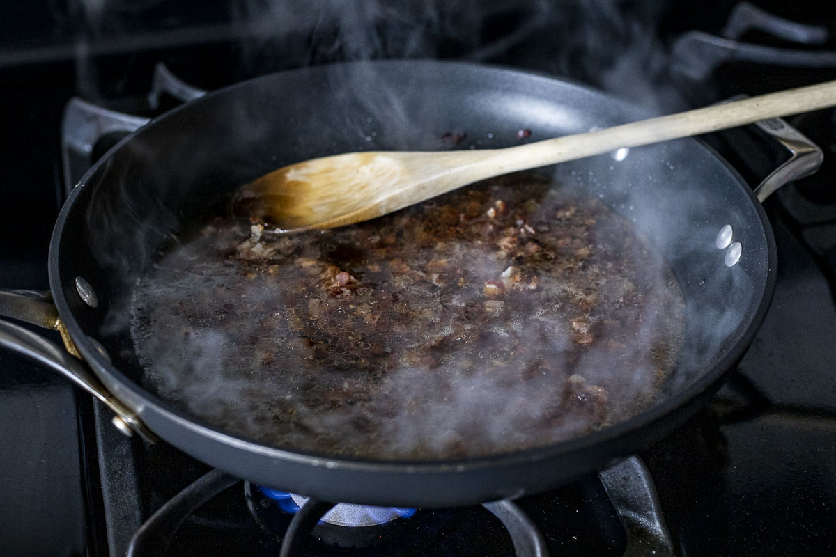 pancetta and broth in a skillet.