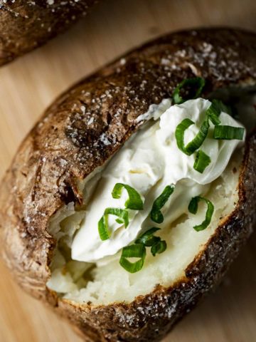 baked potatoe with sour cream and chives in the middle