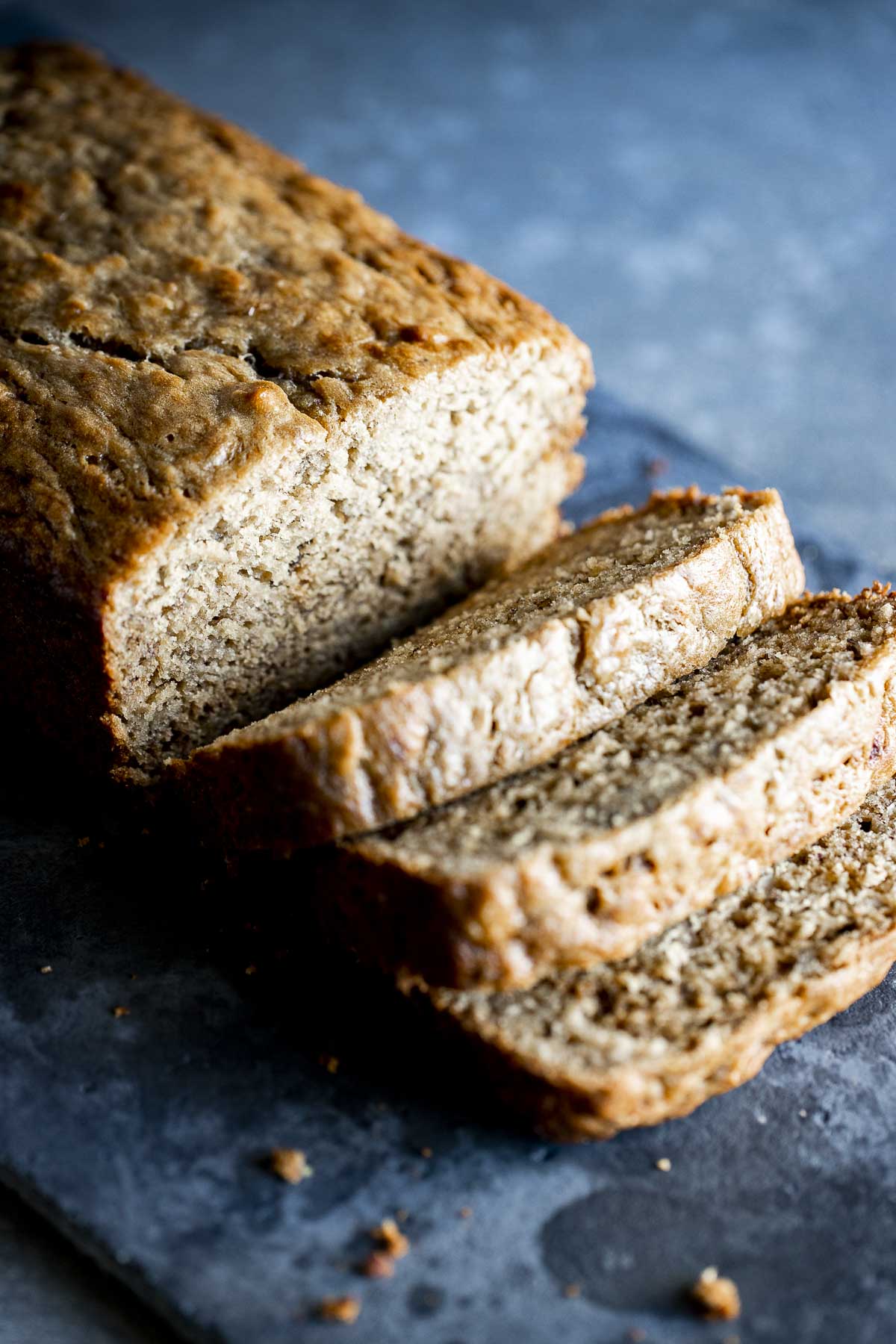 a loaf of brown banana bread being sliced into pieces