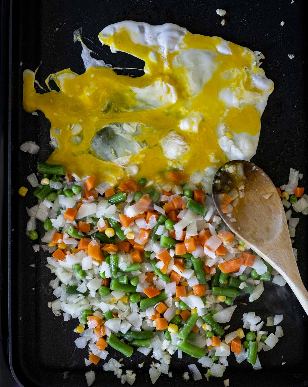 diced carrots and green beans with beaten eggs on white rice.