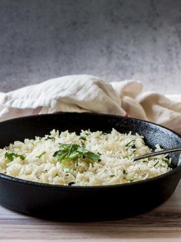 Instant Pot cilantro lime rice in a skillet with a fork inserted into it.