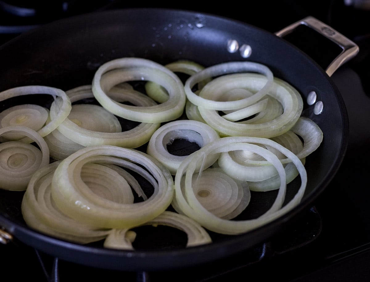Onions being sauteed in a skillet.