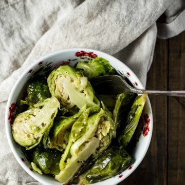 Overhead view of brussels sprouts in a bowl with a spoon.