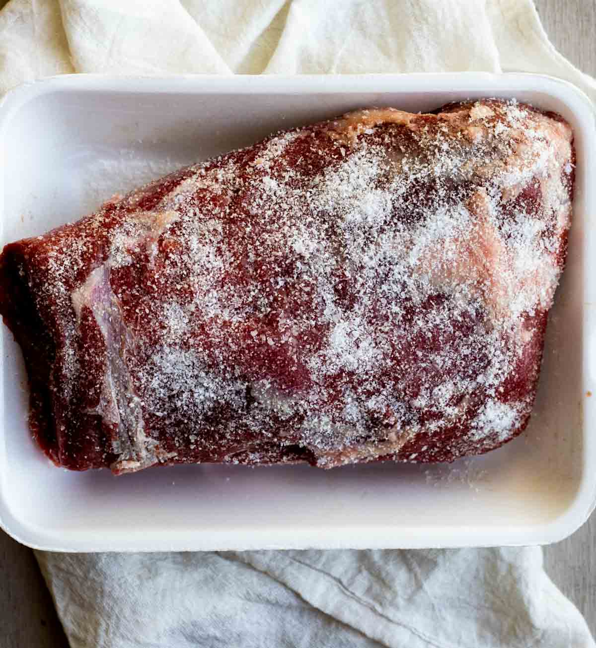 close up view of Roast Beef in a white pan with seasoning