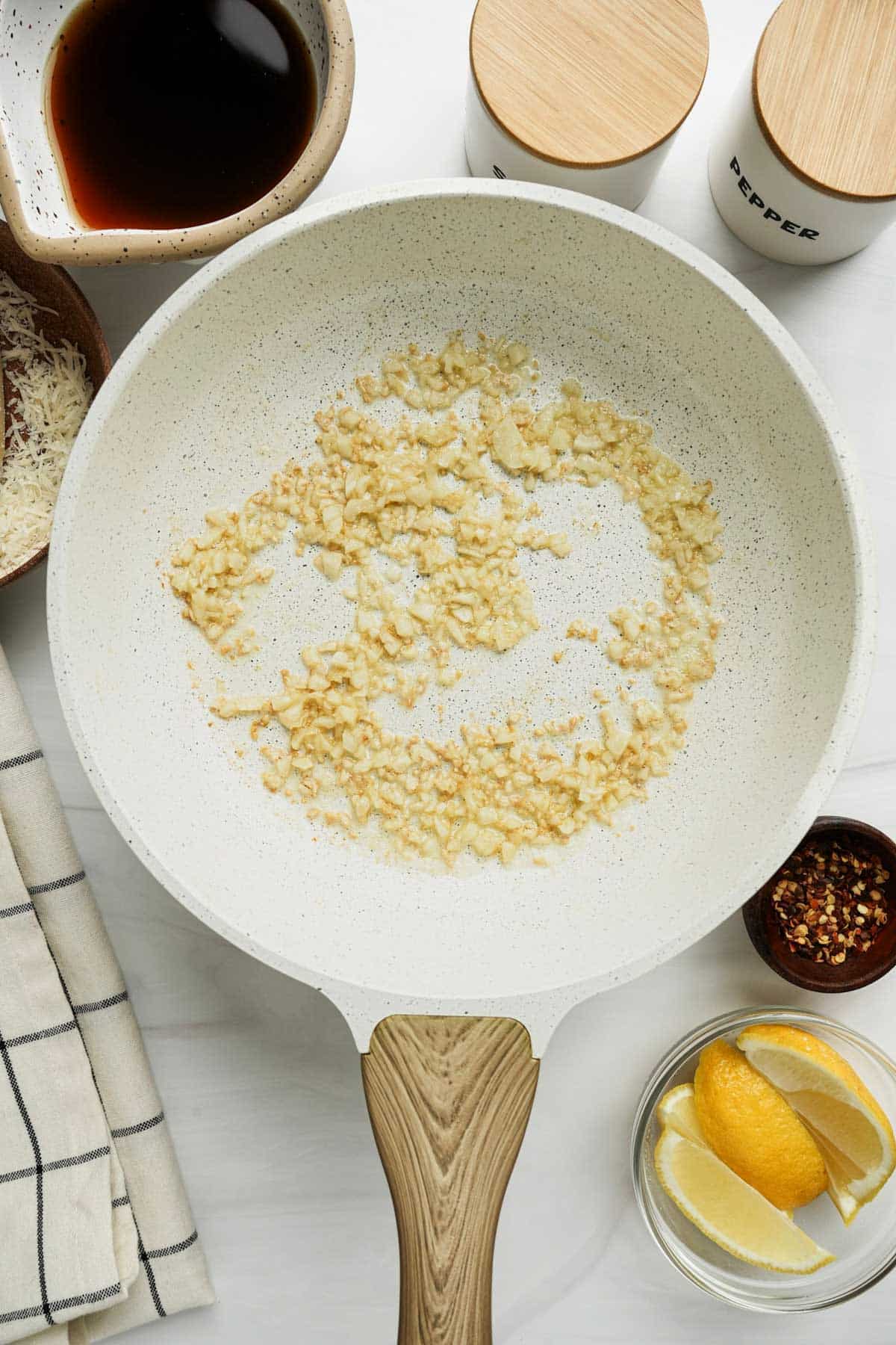 garlic cooking in a white skillet