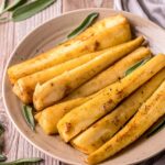 a plate of cooked parsnips garnished with fresh herbs