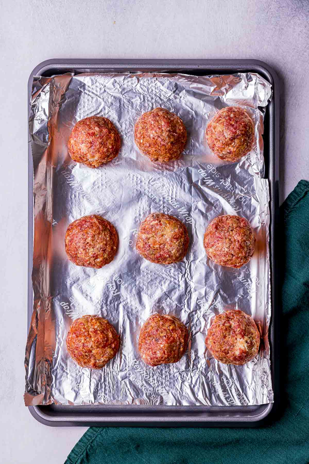 raw meatballs on a baking sheet