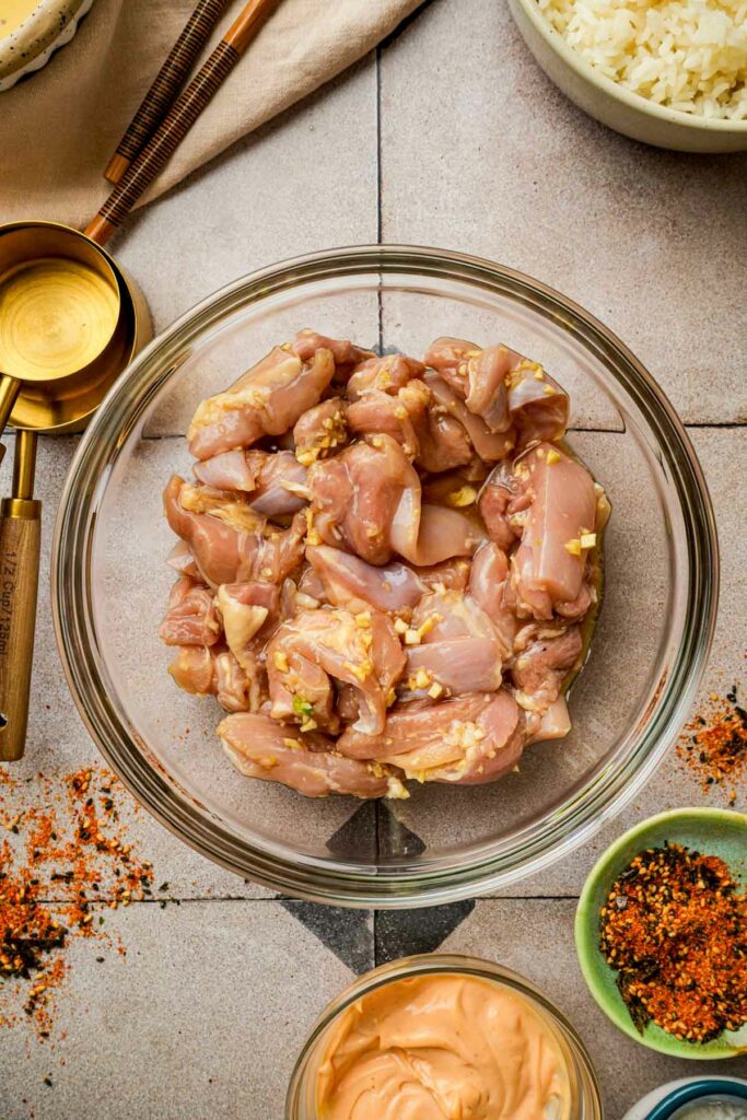 raw chicken in a bowl with a brown marinade to make karaage don