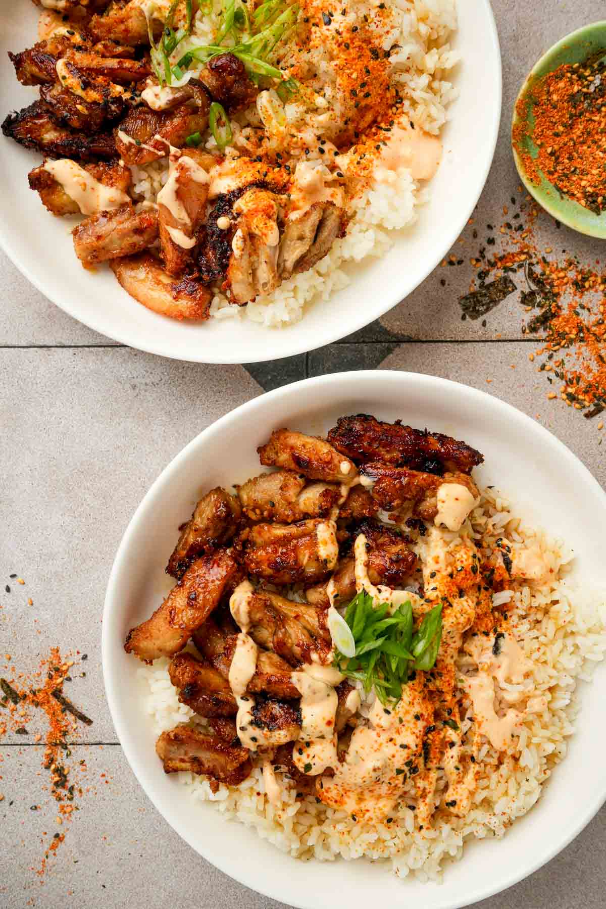 2 chicken karaage donburi garnished with pepper and green onions