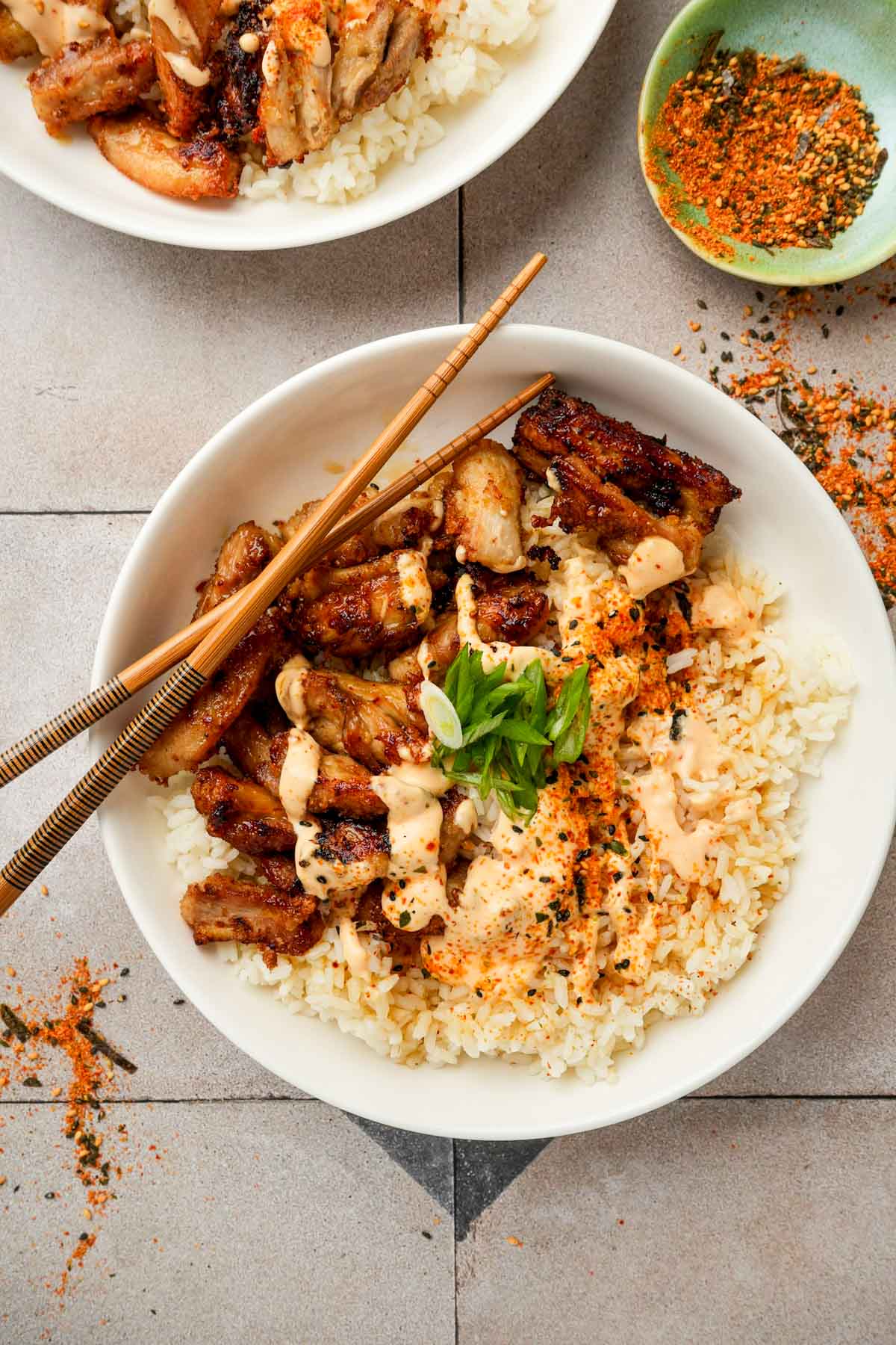 a bowl of karaage don (fried chicken rice bowl) with chopsticks and green onions