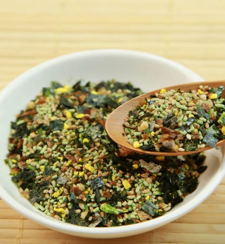 a spoon of furikake over a bowl of green furikake