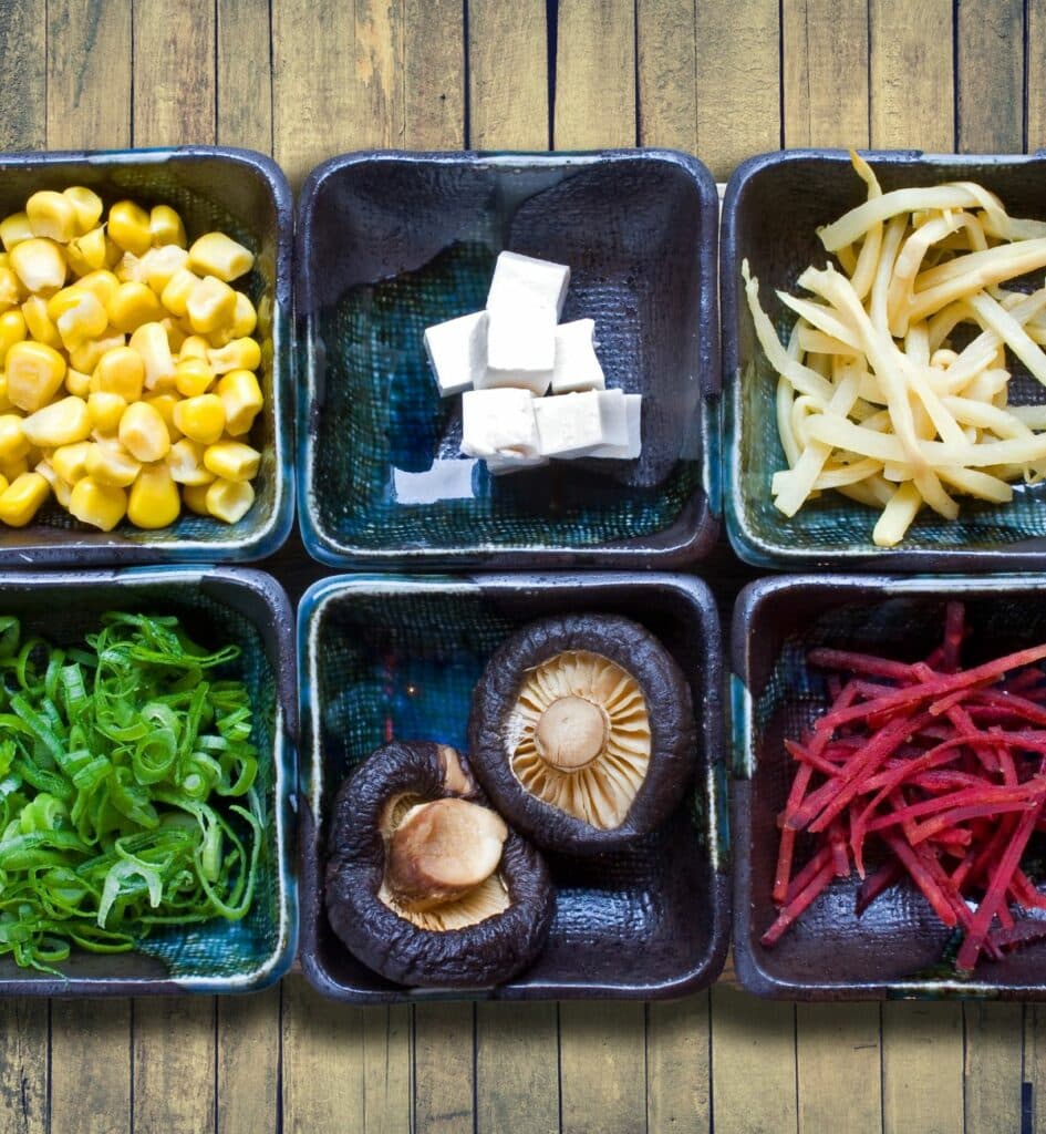 small bowls of sliced vegetables lined in a row