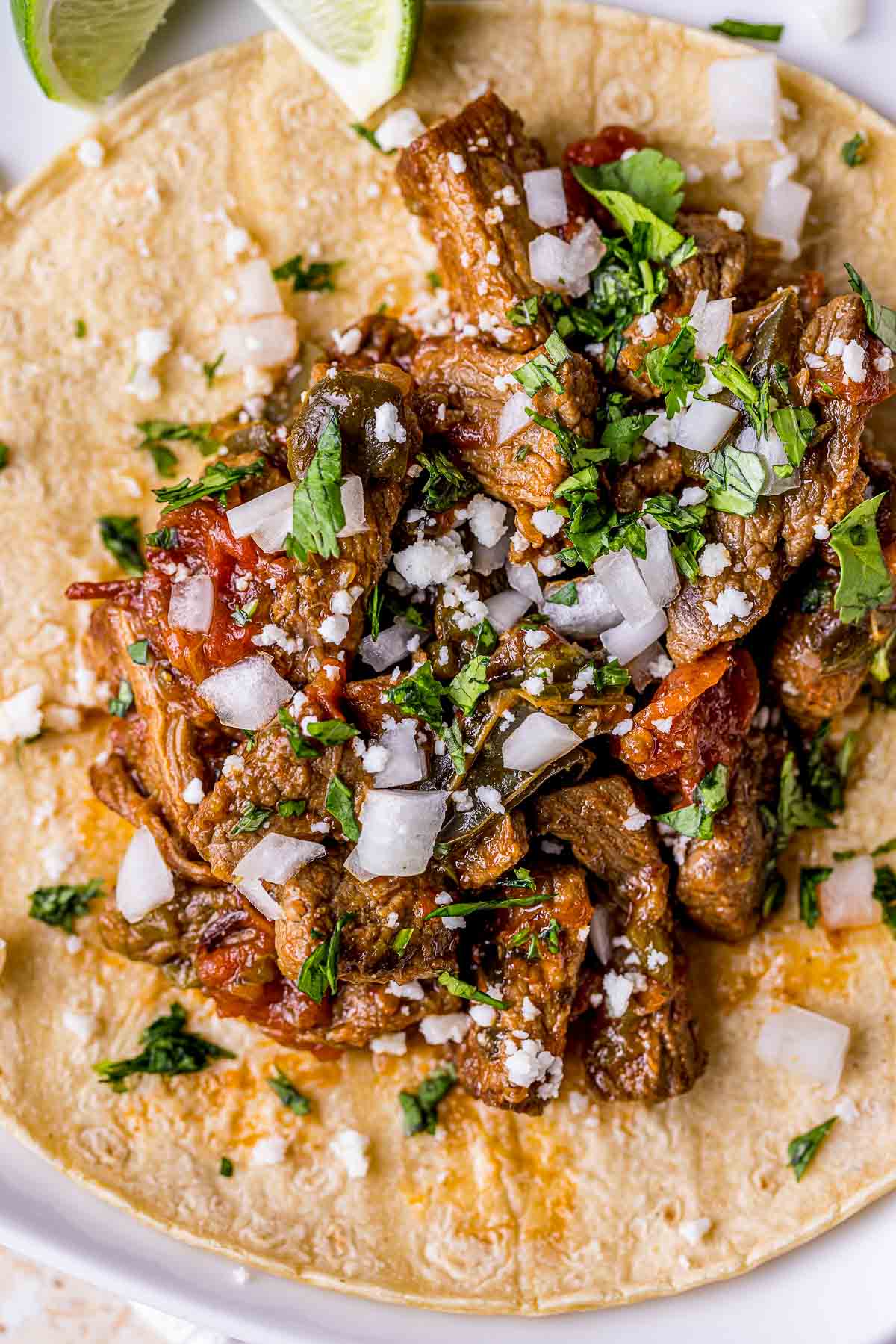 carne picada on a tortilla with onion and cilantro