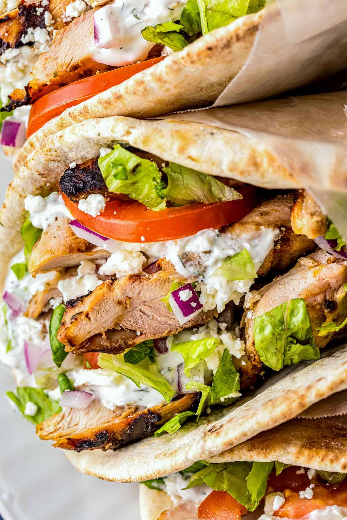 grilled chicken on a pita with vegetables and white sauce