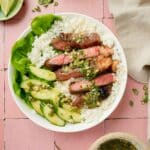 a plate of sliced beef and rice with veggies