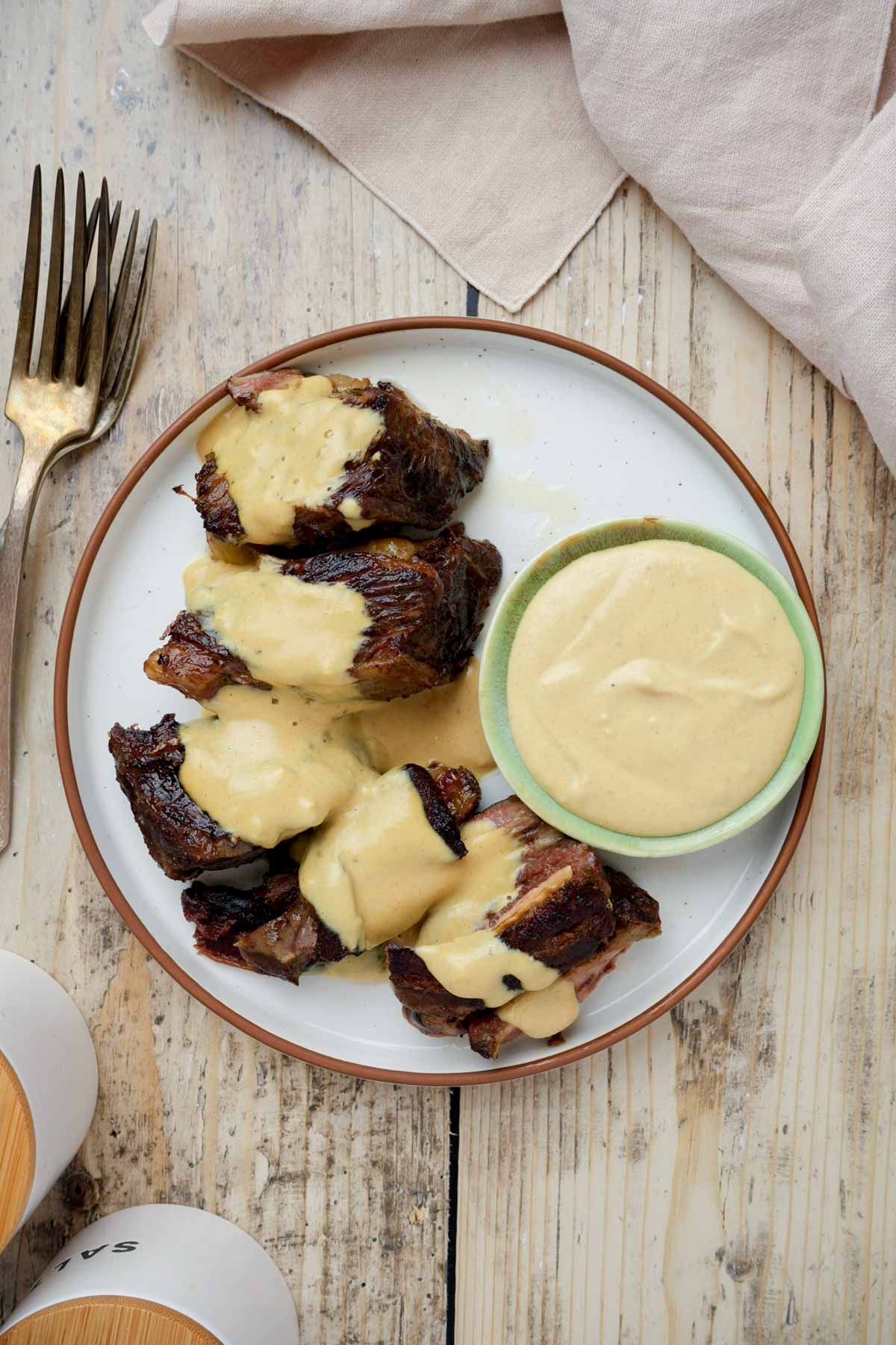 short ribs on a plate with yellow sauce