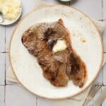 a steak on a plate with butter on top