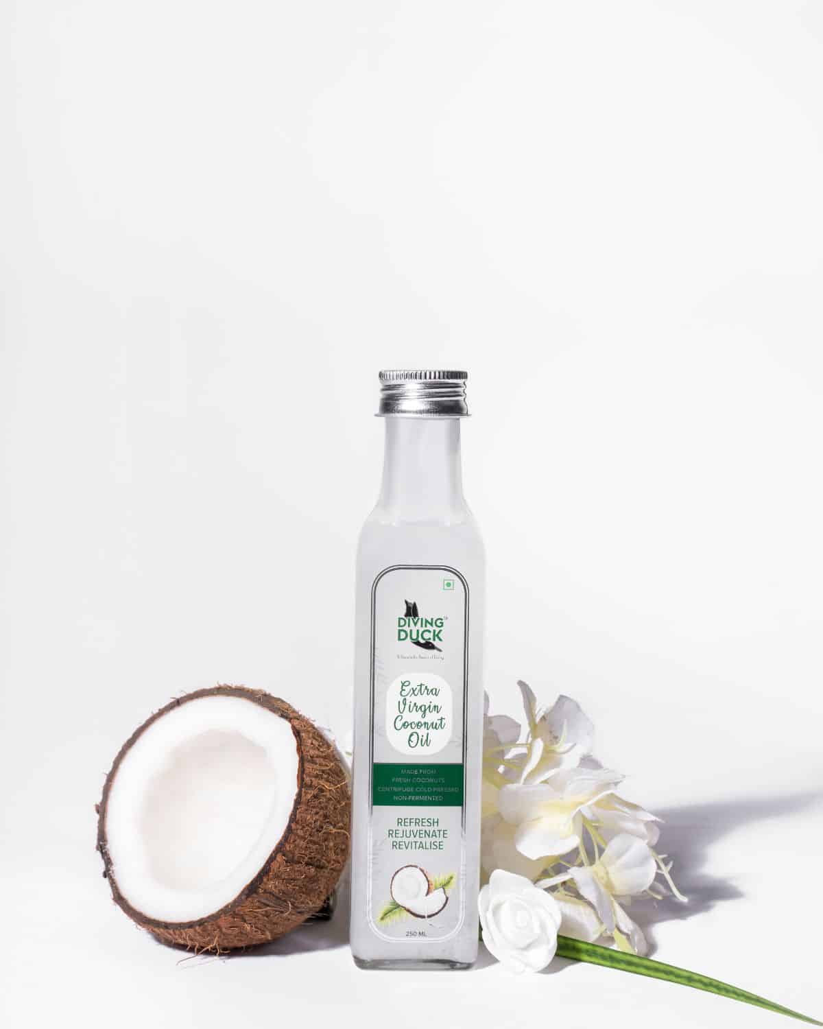 a bottle of coconut oil with fresh coconut next to it.