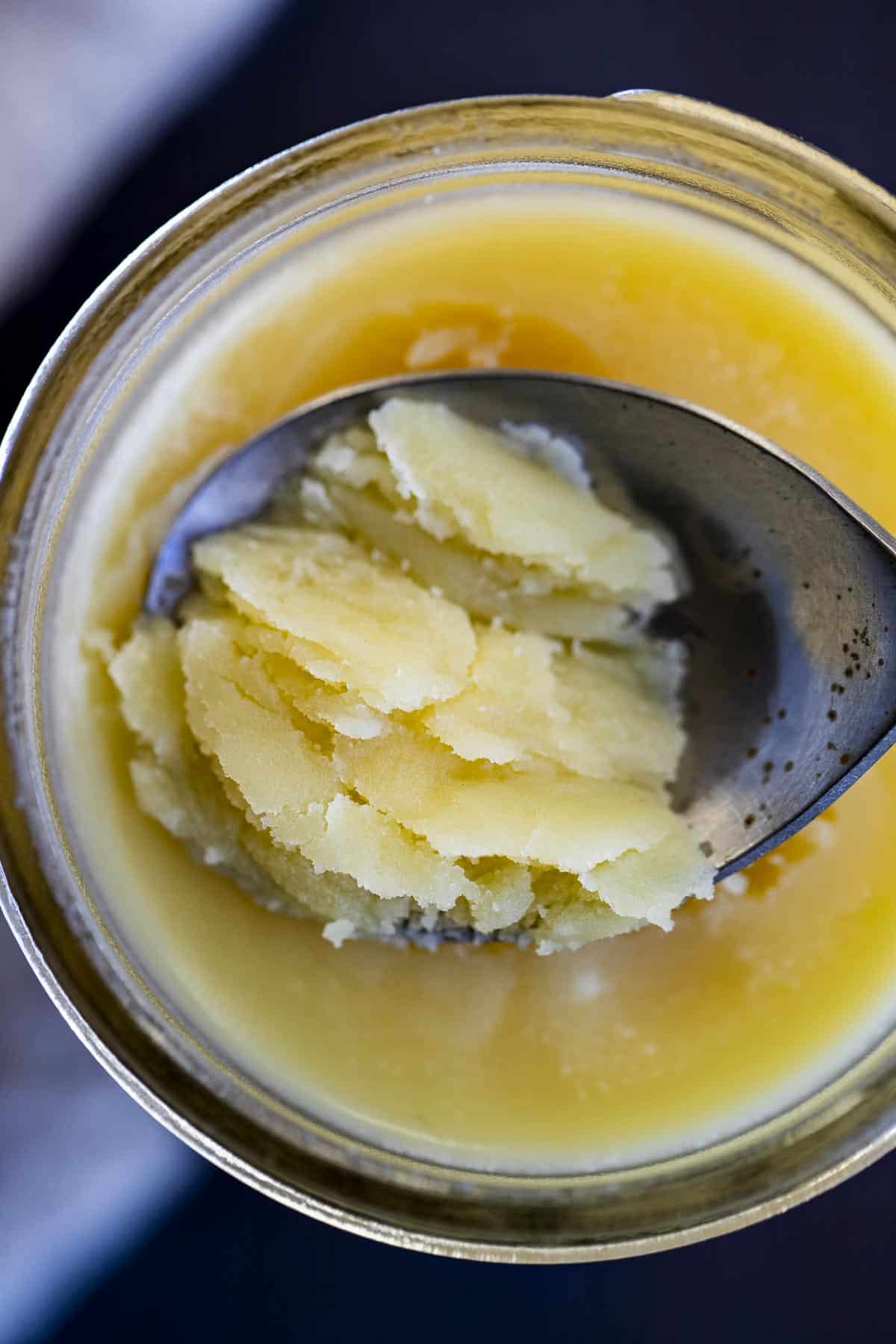 a spoon with solid ghee on it.