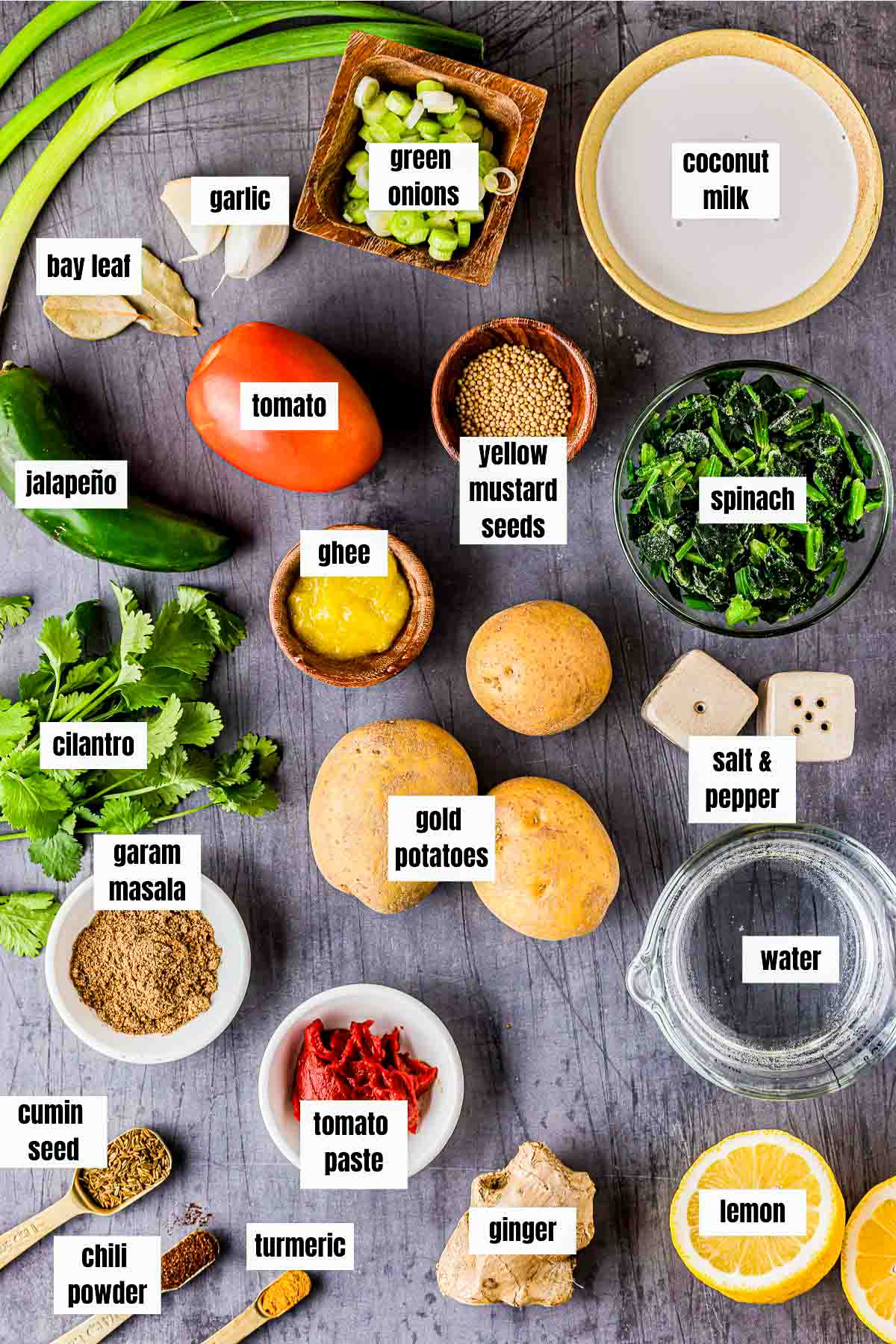 ingredients for saag aloo on a grey board