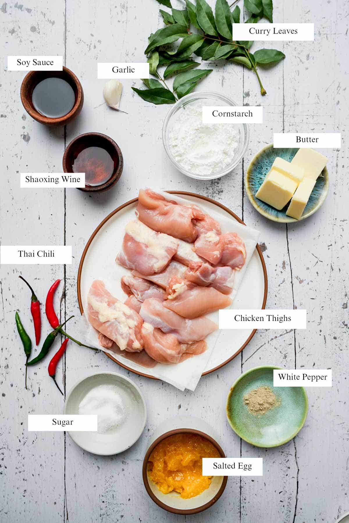 ingredients for salted egg chicken on a light board with labels