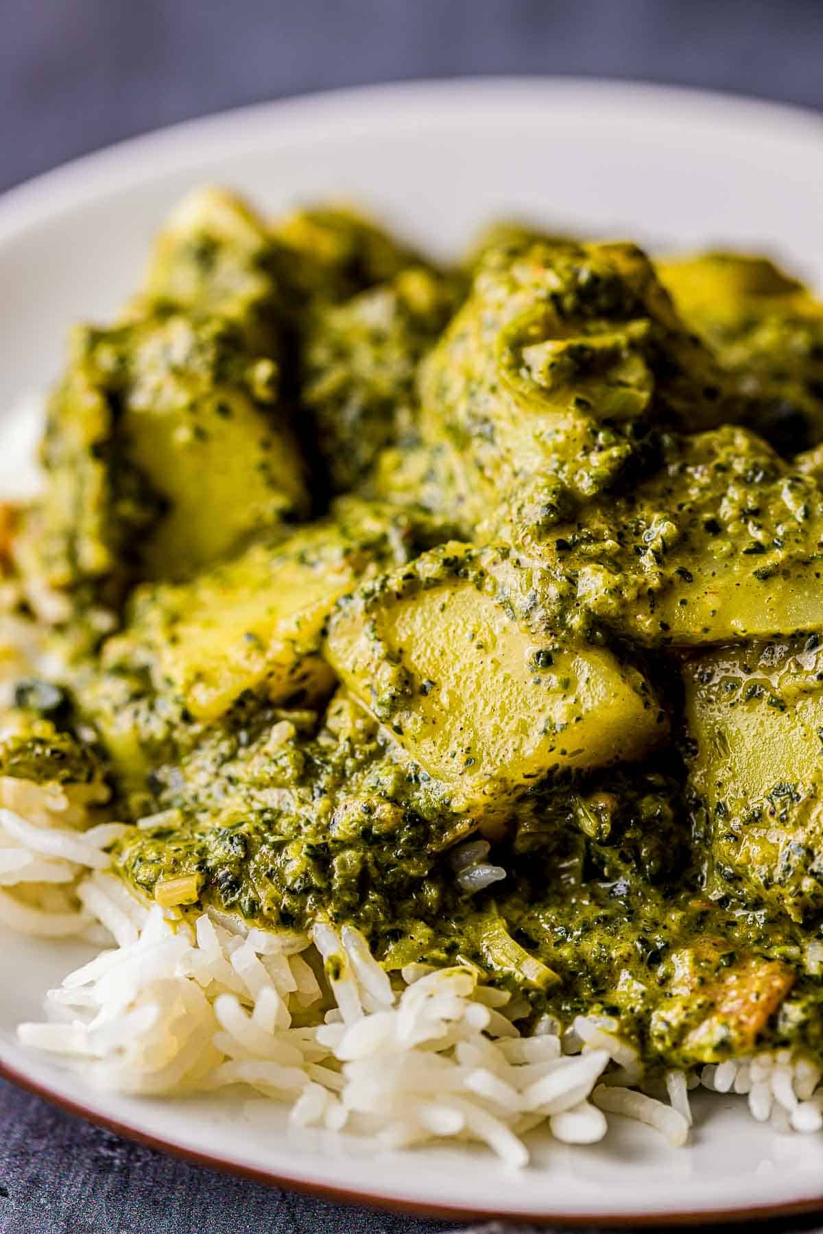 saag aloo (spinach potatoes) being served on a plate over rice