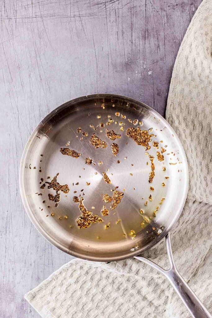 spices toasting in oil in a skillet