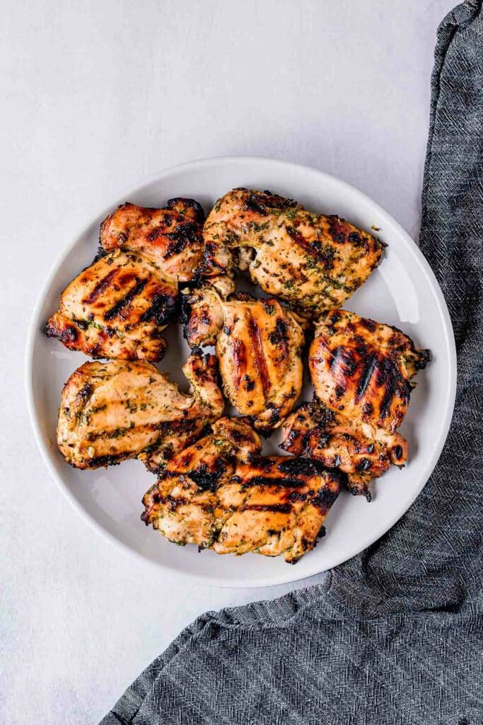 grilled chicken thighs on a white plate