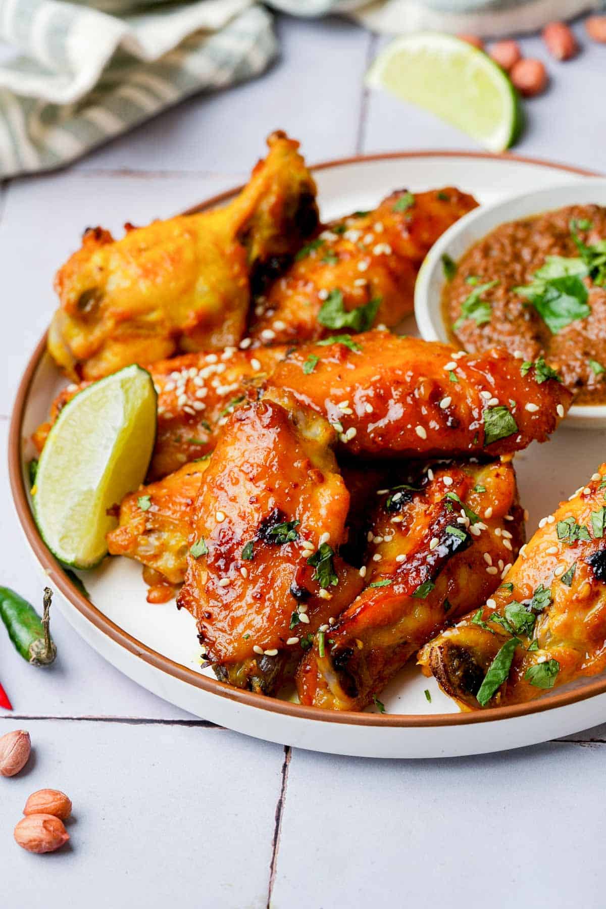 caramelized thai chicken wings garnished with cilantro and lime