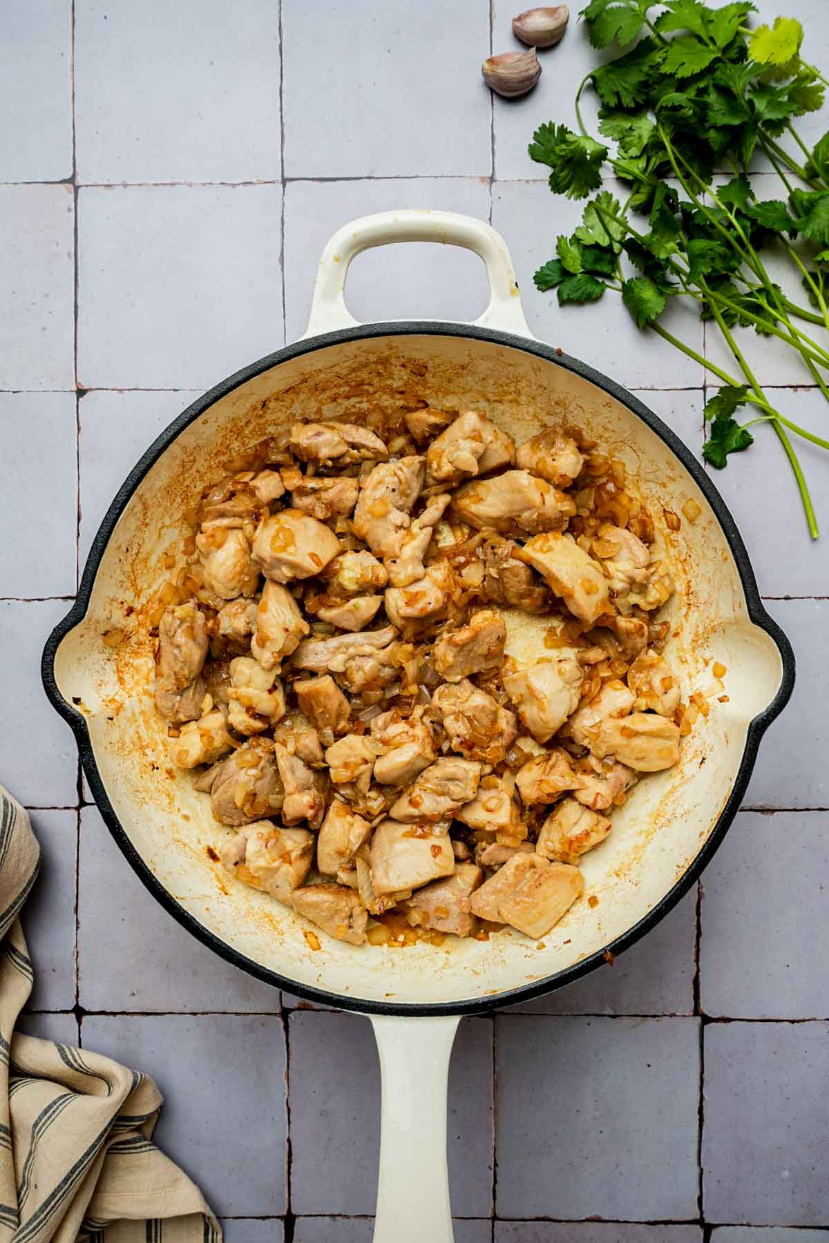 chicken and spices cooking in a skillet.