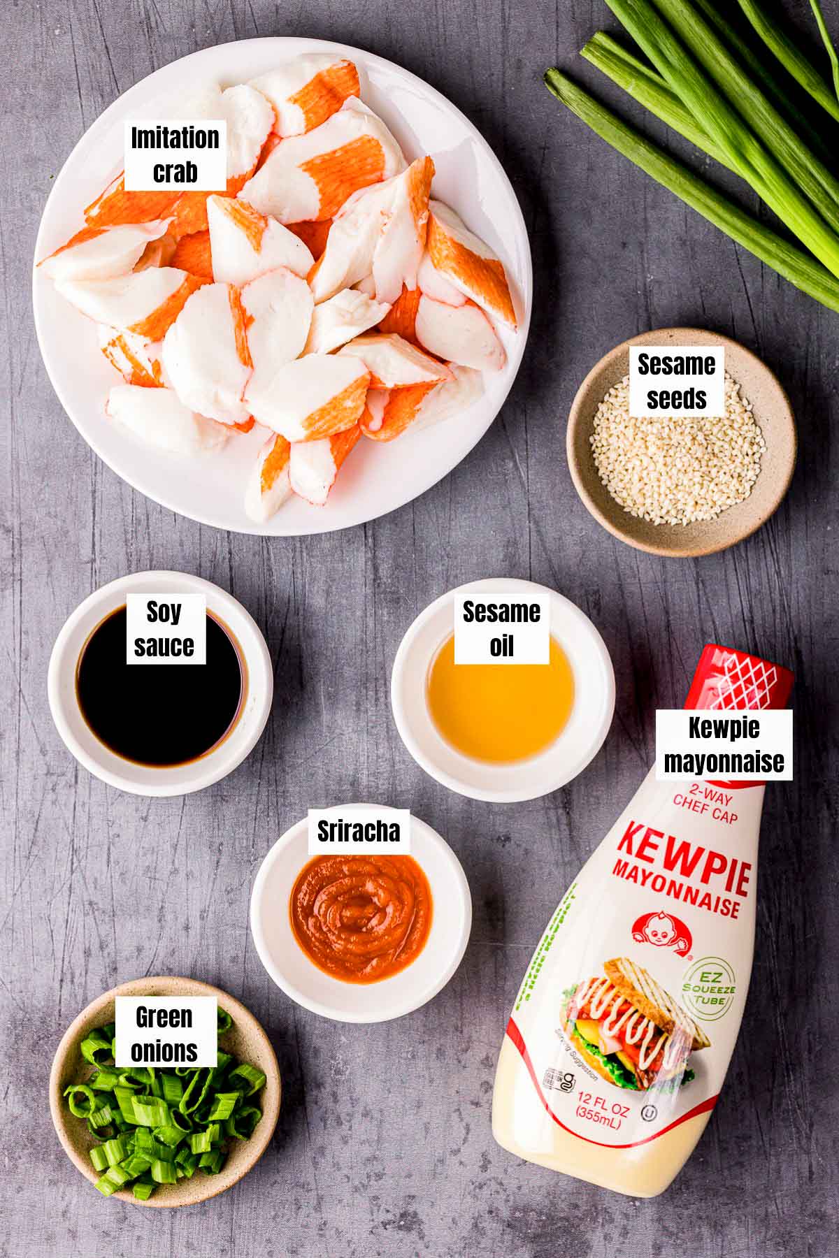 ingredients for sushi crab mix on a gray board with text labels