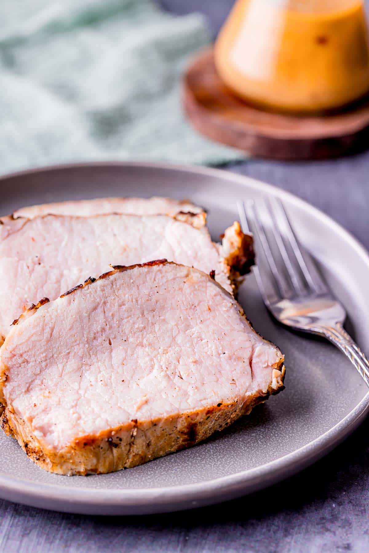 slices of pork on a plate with a fork.