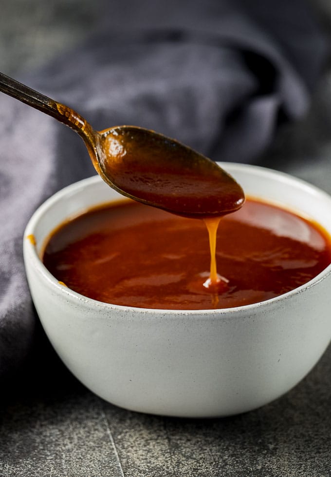 red bbq sauce in a bowl with a spoon