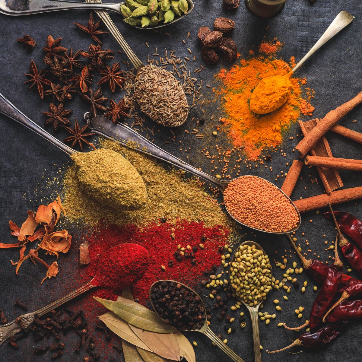 whoel and ground spices on a dark surface