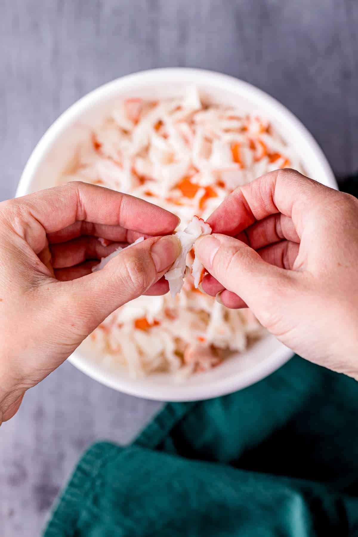 tearing up pieces of imitation crab with fingers
