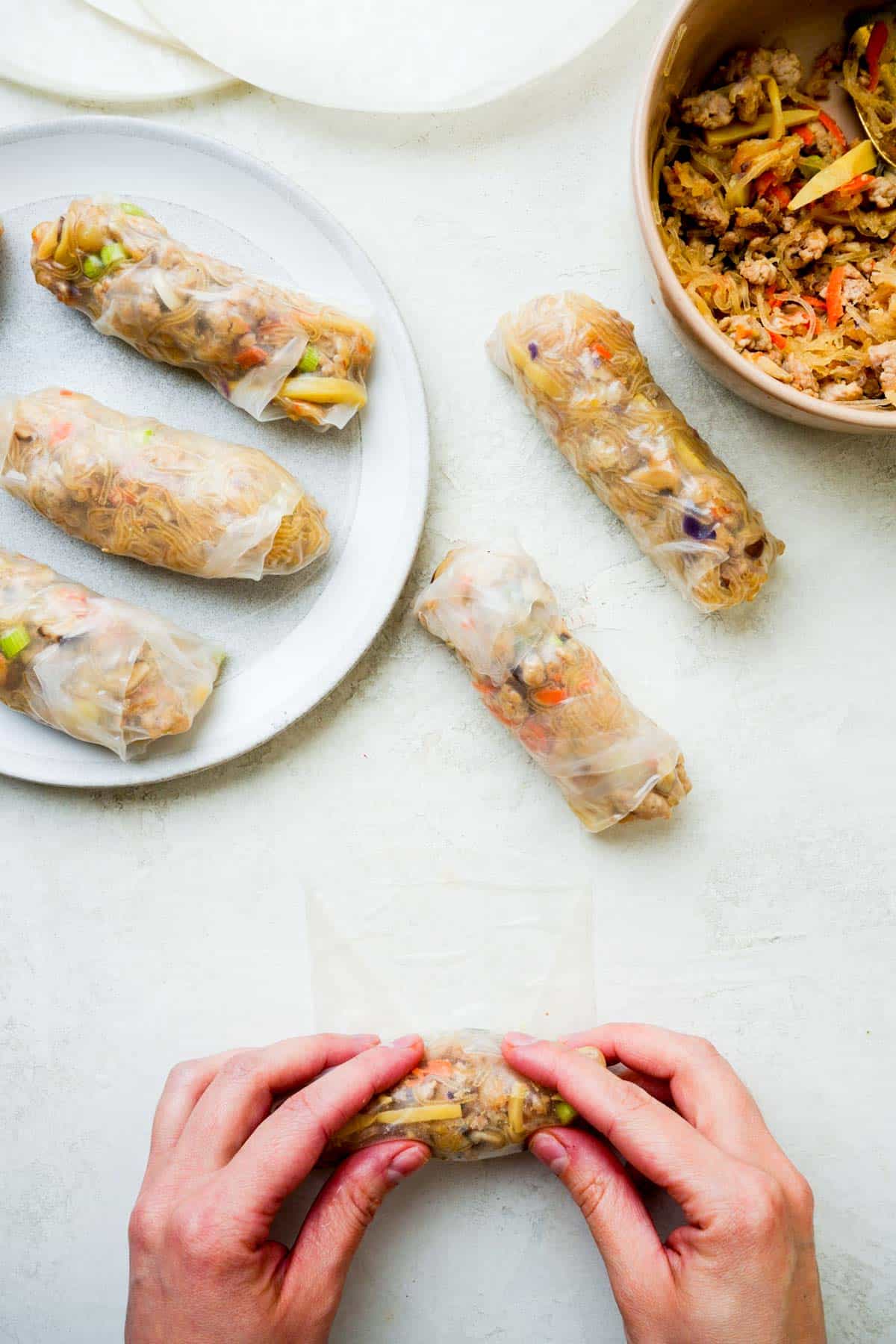 hands rolling spring rolls.