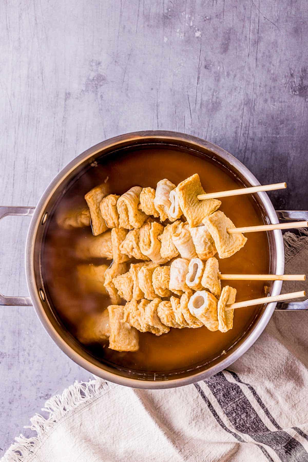 skewered fish cakes in clear broth.