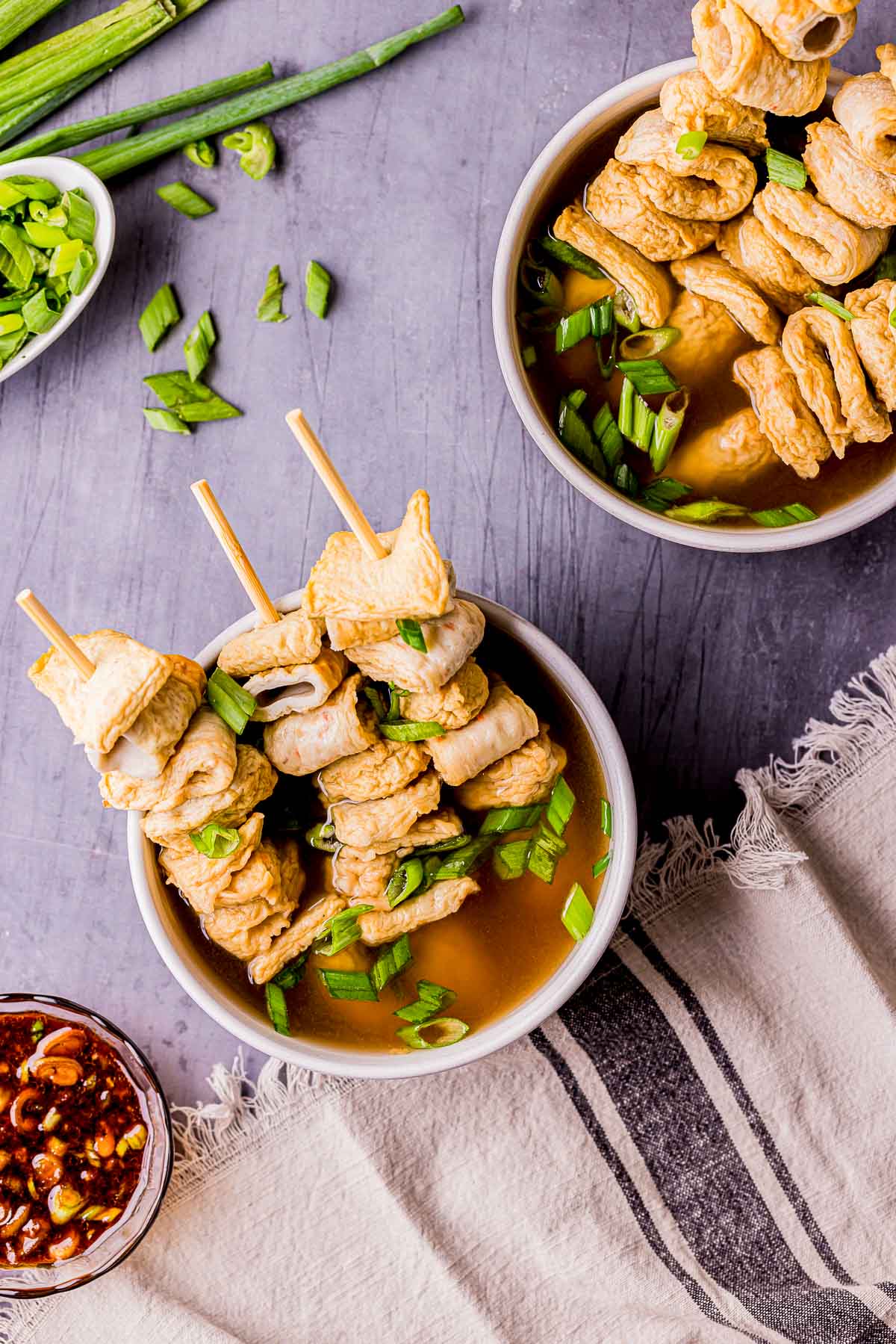 bowls of fish cakes with broth and green onions.