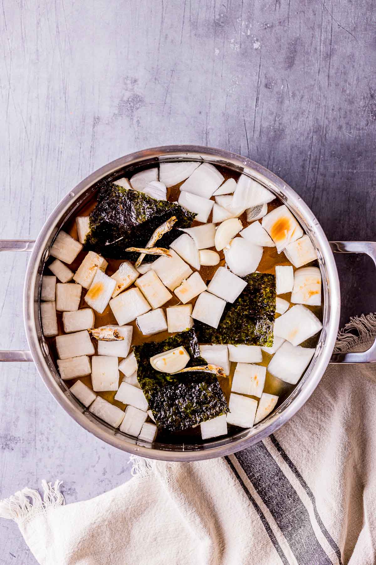 a pot of diced radish, broth and seaweed cooking.