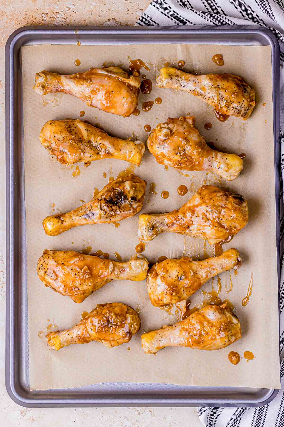 chicken drumsticks arranged on a baking sheet,