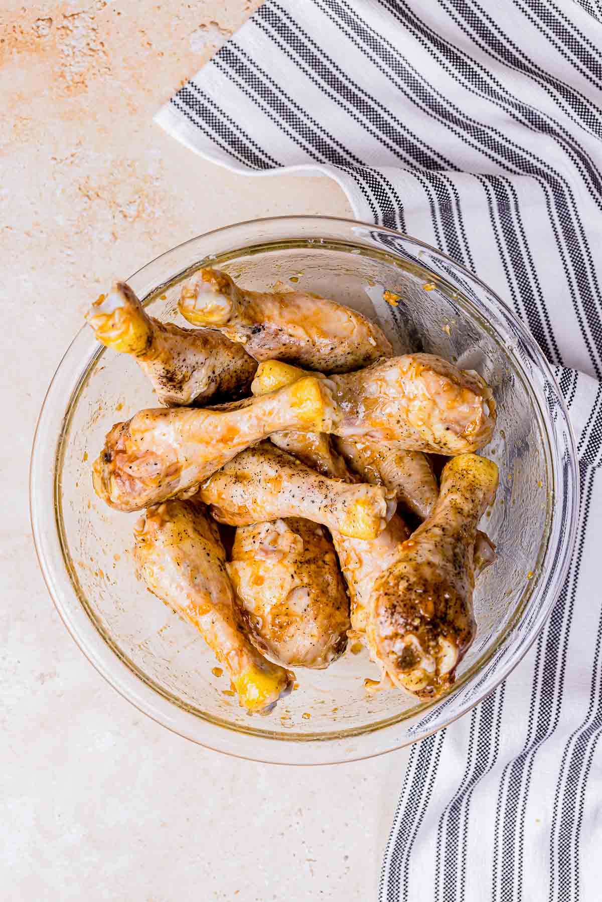 sous vide chicken drumsticks in a bowl tossed in a glaze.